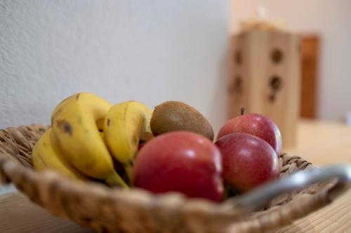 a basket of apples and bananas on a table at Apartments Kaserott in Villnoss