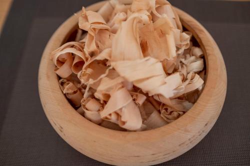 a wooden bowl filled with mushrooms on a table at Apartments Kaserott in Villnoss