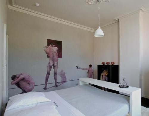 ブルージュにあるBruges by Nightのピンクのダンサーが壁に描かれたベッドルーム