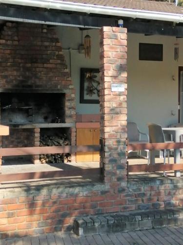 a brick fireplace in front of a house at Farm View Guest House in East London