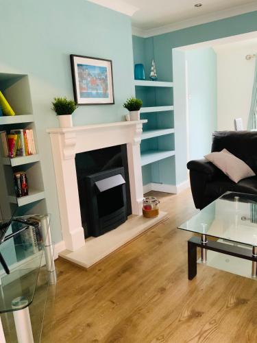 a living room with a fireplace and a couch at Furzy House in Pembrokeshire