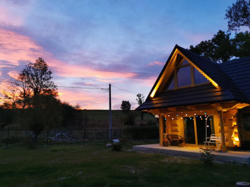 a small house with a sunset in the background at Stylowa Chata in Zakopane
