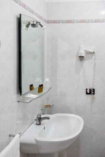 a white bathroom with a sink and a mirror at Hotel Villa Maria in Crispiano