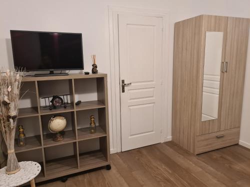 un salon avec une télévision sur une étagère dans l'établissement Appartement de vacances a St Pierre du Vauvray, à Saint-Pierre-du-Vauvray