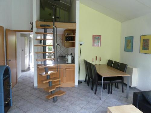eine Küche und ein Esszimmer mit einem Tisch und einer Wendeltreppe in der Unterkunft Ferienhaus Lisakowski in Warmenhuizen