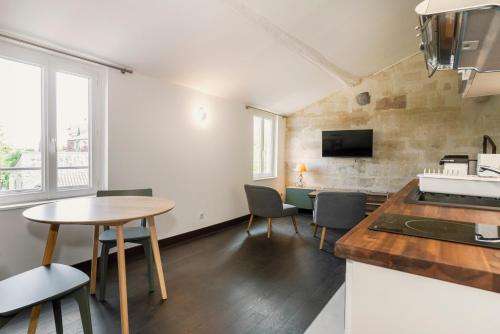 une cuisine et un salon avec une table et des chaises dans l'établissement Saint Eloi - duplex centre historique de VILLENEUVE LES AVIGNON, à Villeneuve-lès-Avignon