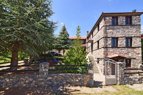 una vecchia casa in pietra con cancello e recinzione di Luxurious Residence at the Village Square a Palaios Agios Athanasios