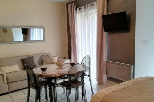 a room with a table and chairs and a couch at LE PORTE VERRIER - MEUBLE CLASSE 3étoiles - Hypercentre - Terrasse 30M2, Vue Parc in Vichy