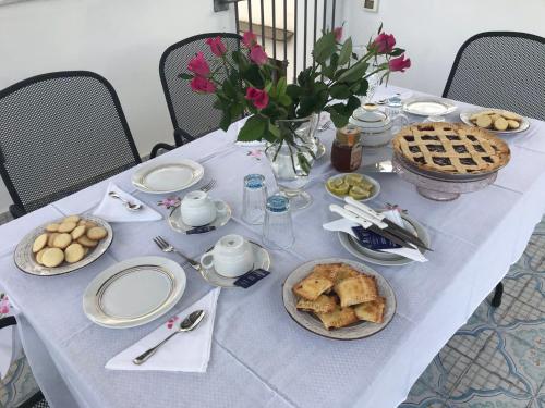 a table with a blue table cloth with food and flowers at Casa Vacanze Flavia in Palermo