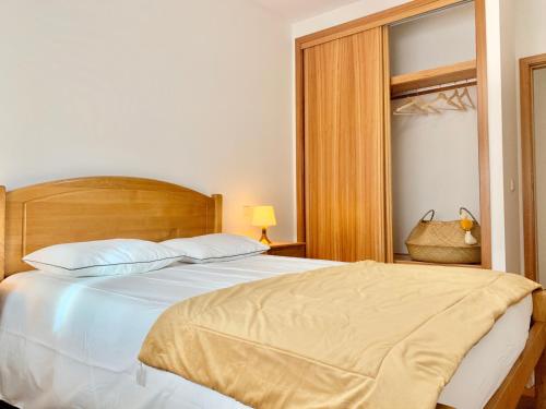 um quarto com uma grande cama branca e uma janela em University of Minho- INL Campus Gualtar Apartment em Braga