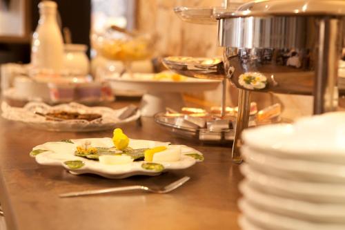 a counter with plates of food on a table at Hotel Römerstadt in Gersthofen