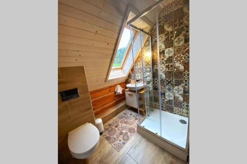 a bathroom with a toilet and a glass shower at Kolíska pokoja in Osturňa