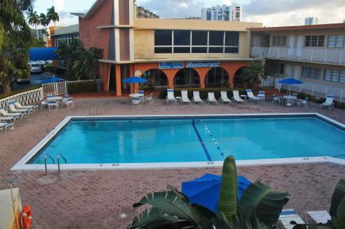 a large swimming pool in front of a large building at Knights Inn Hallandale in Hollywood