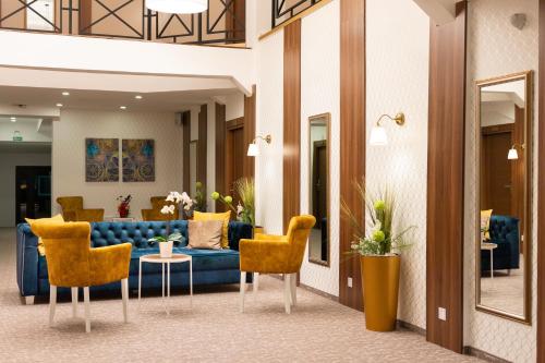 a lobby with a blue couch and yellow chairs at Luxury Rooms Skadarlija in Belgrade