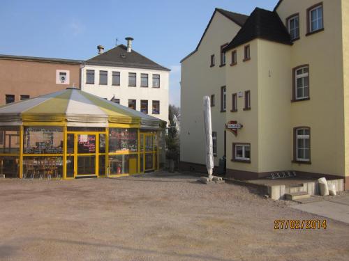 un magasin avec portes jaunes à côté de deux bâtiments dans l'établissement Hotel Haus Marienthal, à Zwickau
