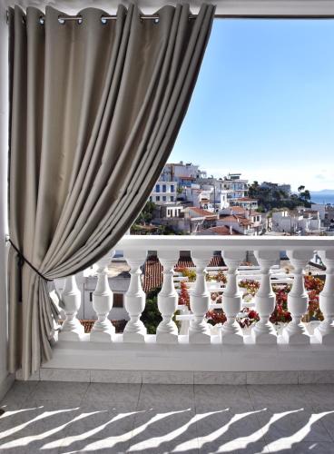 a window with a curtain and vases on a ledge at Angelos Design Suites in Patitiri