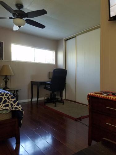 1 dormitorio con escritorio, silla y ventilador de techo en Woodland Hills BEST Priced Room, en Woodland Hills