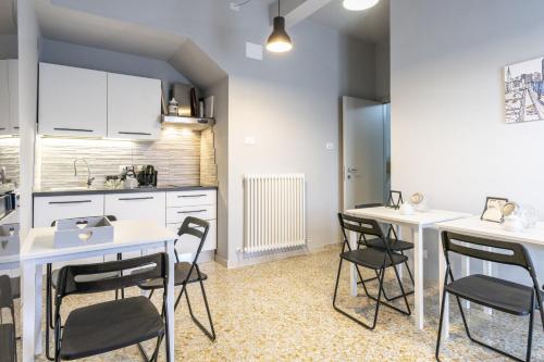 a kitchen with white tables and chairs in a room at 018 - Appartamento Il Lemme - Nel Cuore di Gavi in Gavi