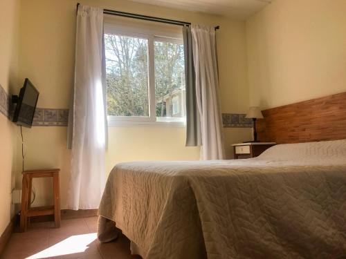 皮納馬爾的住宿－Las Caracolas Apart Familiar，一间卧室设有一张床和一个窗口