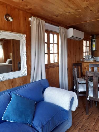 a living room with a blue couch and a table at Cabañas Puente Negro in Puente Negro