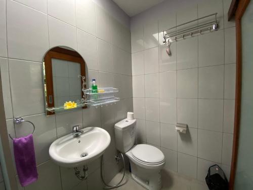 Villa Melanting في كارانجاسيم: حمام مع مرحاض ومغسلة ومرآة