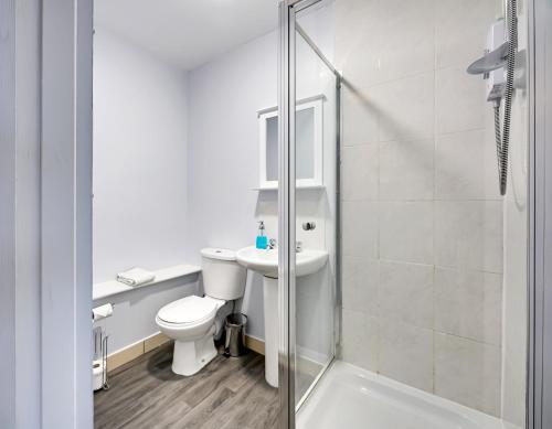 uma casa de banho com um WC, um lavatório e um chuveiro em Grey Stone Studio Apartments em Halifax