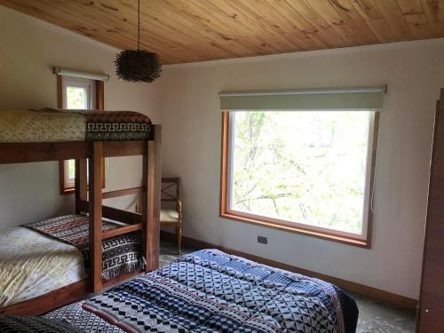 a bedroom with two bunk beds and a window at Cabañas del pillan in Pucón