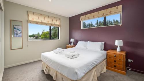 une chambre avec un grand lit et deux fenêtres dans l'établissement Heritage Village - Villa #5, à Wanaka