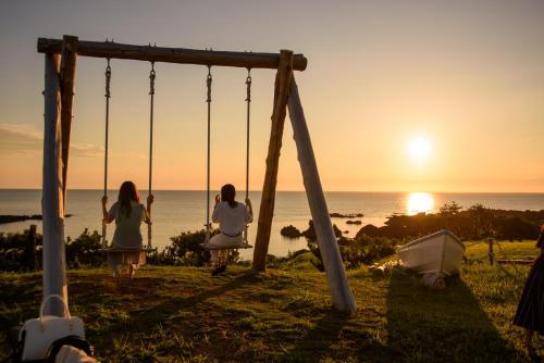 two women sitting on a swing watching the sunset at Sado Resort Hotel Azuma in Sado