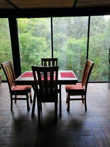 a table and chairs in a room with a window at Mazamitla Pinos del Rio in Mazamitla