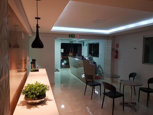 a kitchen and living room with a table and chairs at Aero Inn Hotel in Uberlândia