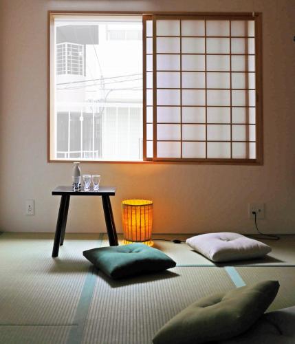 a room with a table and two pillows in front of a window at Teppanyaki House in Kyoto