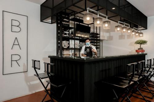 a man wearing a face mask behind a bar at D' LA TORRE HOTEL in Managua