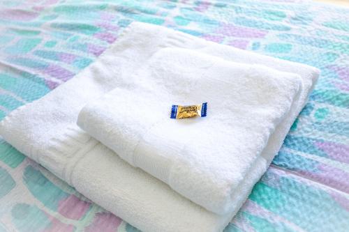 Una toalla blanca con un alfiler en la cama en Corals B&B Apartment, en Denia