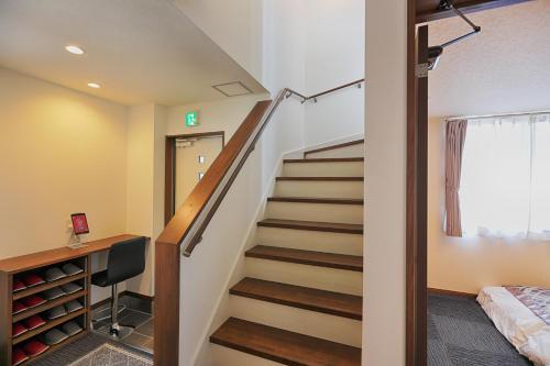 a staircase in a room with a bed and a desk at Villas Asama no Iori in Fujiyoshida