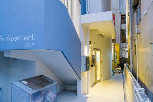 a blue and white building with a stairway at Good Life Apartment in Naha