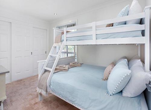 a bedroom with a bunk bed with blue pillows at kims@kiama in Kiama