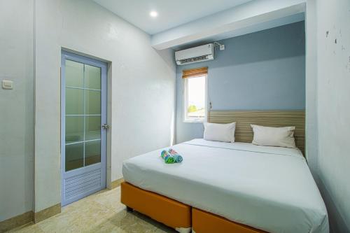 a bedroom with a bed and a window at My Home Aceh in Banda Aceh