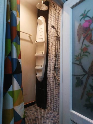 a bathroom with a toilet and a shower at Acozyposhtel in Bangkok