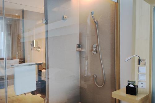 um chuveiro com uma porta de vidro na casa de banho em Novotel Nanjing East Suning em Nanquim