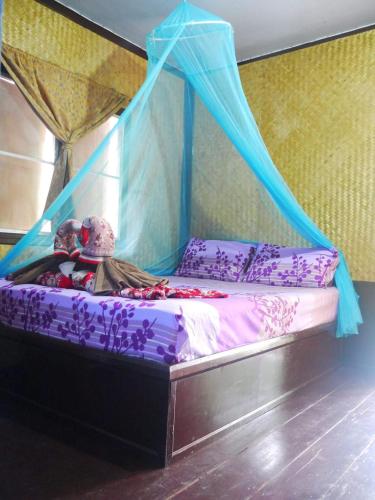 a bed with a canopy with a teddy bear on it at Mata Guesthouse in Ko Kood