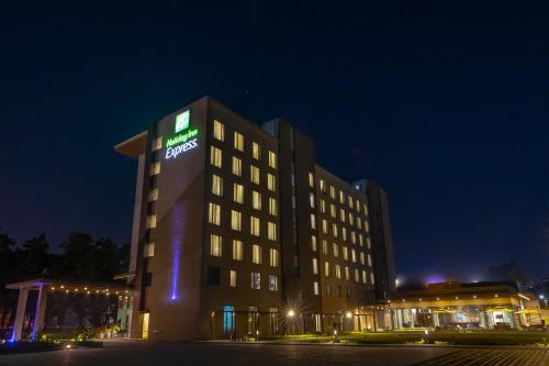 a hotel building with a sign on it at night at Holiday Inn Express Kolkata Airport by IHG in Kolkata
