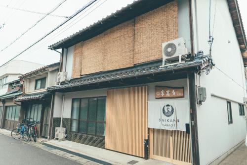 um edifício com um sinal na lateral em ゲストハウス 宰嘉庵 かなで GuestHouse Saikaan KANADE em Maizuru