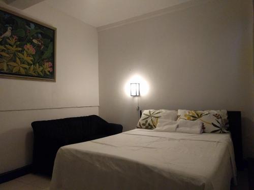 een hotelkamer met een bed en een lamp bij La Trinidad Pension House in Manilla