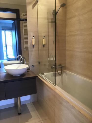 La salle de bains est pourvue d'une baignoire, d'un lavabo et d'une douche. dans l'établissement Platinum Towers Hotel Apartments, à Varsovie