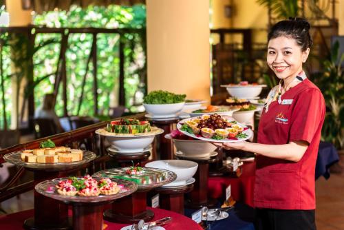 een vrouw die voor een buffet staat bij White Sand Resort Mui Ne in Mũi Né