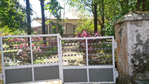 une porte blanche avec des fleurs dans un jardin dans l'établissement Villa Yasmin Malino, à Malino