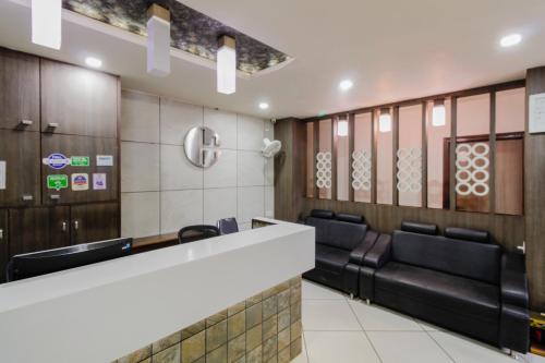 una sala de espera con mesas y sillas de cuero negro en Hotel City Inn, en Ahmedabad