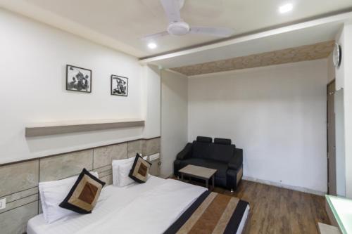 a hotel room with a bed and a chair at Hotel City Inn in Ahmedabad