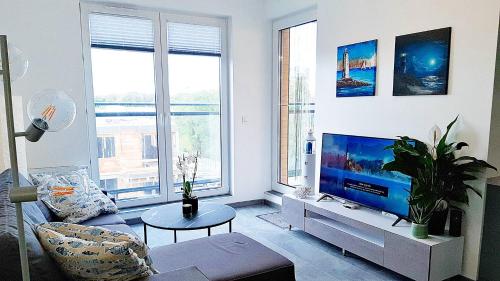 sala de estar con sofá y TV de pantalla plana en Meerblick - widok na morze en Puck